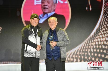 图为中国羽毛球队原总教练李永波为王文教献上奖杯。中新社记者 翟璐 摄