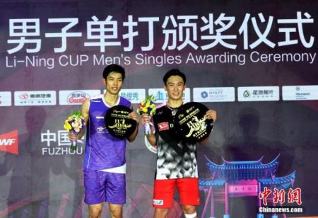 11月10日，2019中国(福州)羽毛球公开赛决赛在福州举行。日本名将桃田贤斗2比1战胜中国台北选手周天成，获得男单冠军。图为桃田贤斗(右)与周天成在颁奖仪式上合影。中新社记者 吕明 摄