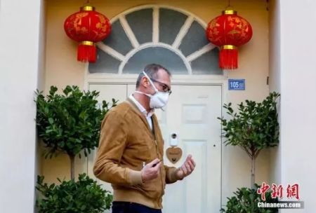 　　克莱因说 “买好这瓶酒就放在那，等这场疫情结束我的太太回到武汉，与她一同打开庆祝。图为菲利普·克莱因在挂着红灯笼的家门口。中新社记者 张畅 摄