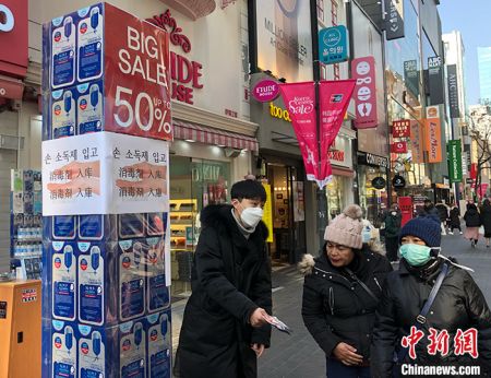 　　受新冠肺炎疫情影响，首尔明洞商区销售人员统一配戴口罩。 曾鼐 摄