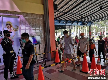 　　图为进入市场的顾客排队接受红外线体温检测。　林永传　摄