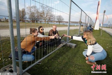 　　资料图：德国瑞士封锁边界，两国民众隔护栏聚餐 。