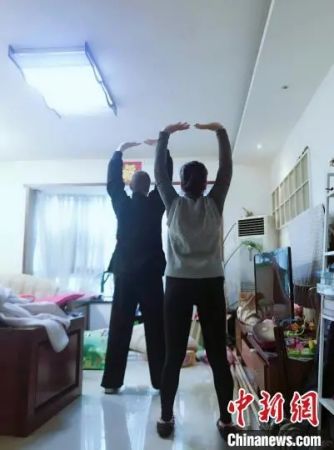 　马丁教妻子练习八段锦。