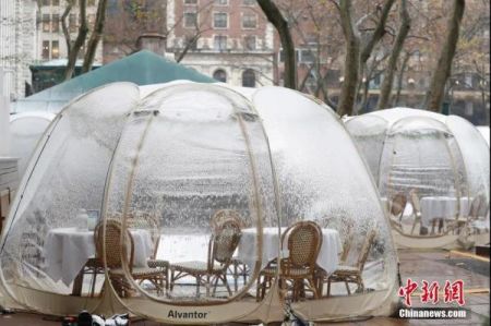 资料图：当地时间12月9日，美国纽约迎来今冬首场降雪，布莱恩公园的户外用餐“泡泡屋”覆盖白雪。中新社记者 廖攀 摄