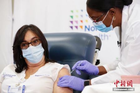 　资料图：当地时间2020年12月14日，美国纽约长岛犹太医疗中心护士史蒂芬妮接种新冠疫苗。当日，辉瑞公司首批近300万剂新冠疫苗陆续运抵美国各地。 中新社记者 廖攀 摄