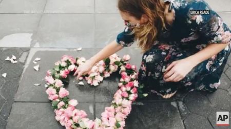 美国艺术家莉比在纽约放置花朵展品。图片来源:美联社新闻视频截图。 美国艺术家莉比在纽约放置花朵展品。图片来源:美联社新闻视频截图。